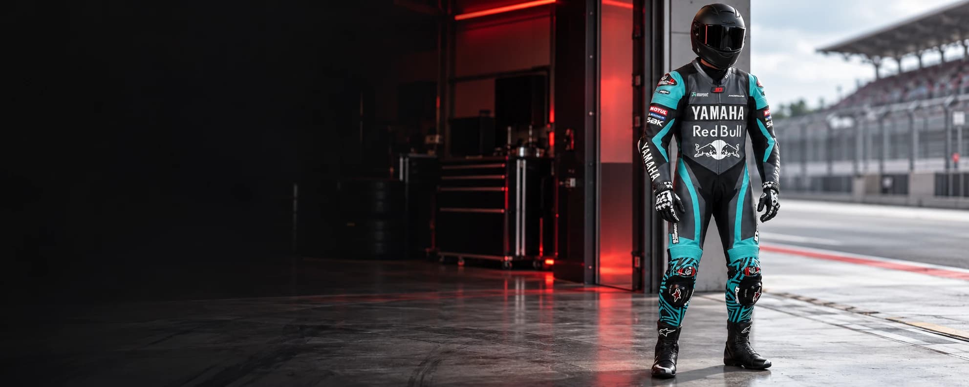 Leathers First custom leather motorcycle race suit worn by a rider in a pit garage
